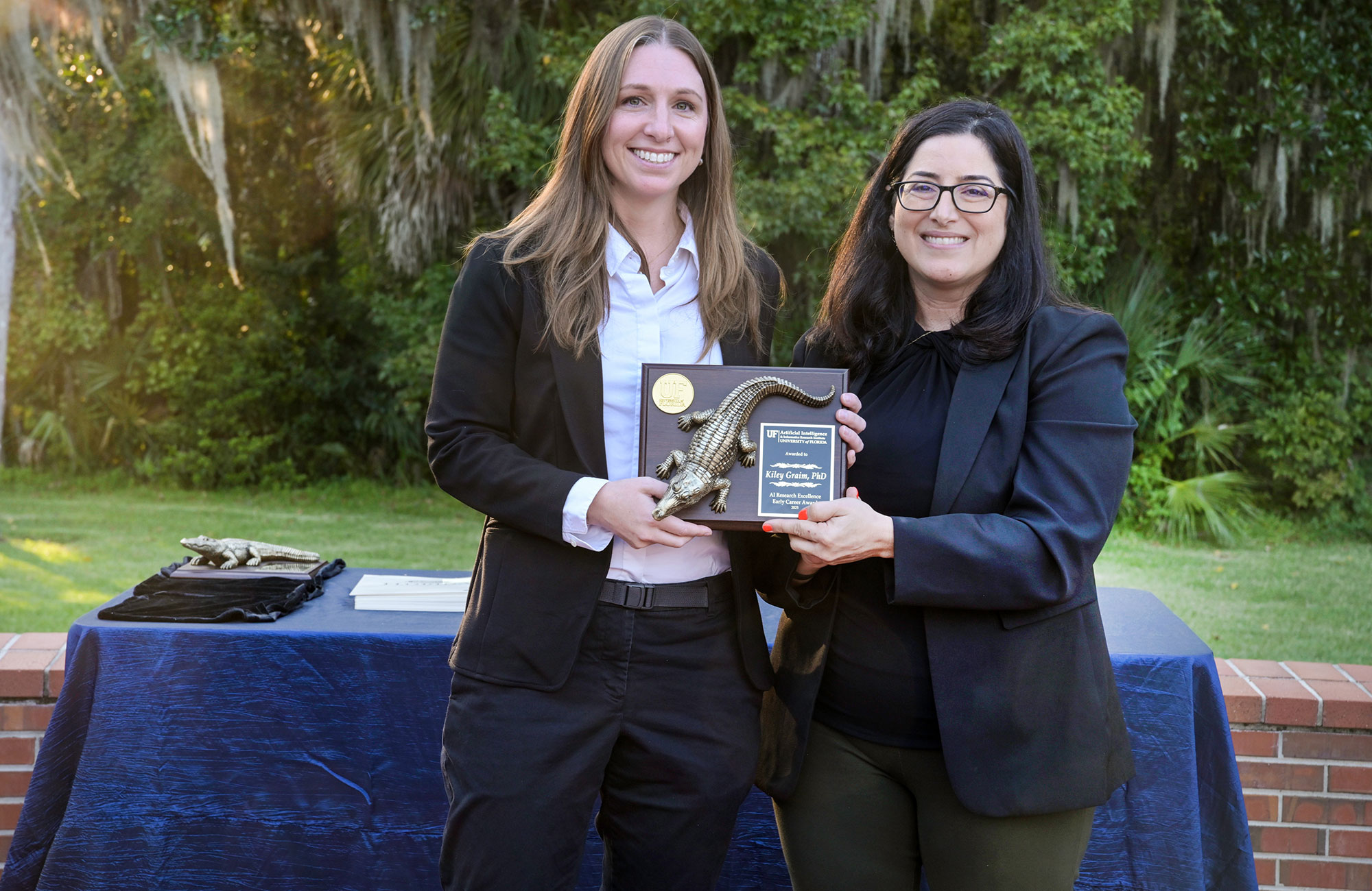 UF Professor Kiley Graim, left, accepts the AI Research Excellence Early Career Award Wednesday from Alina Zare, director of the Artificial Intelligence and Informatics Research Institute.